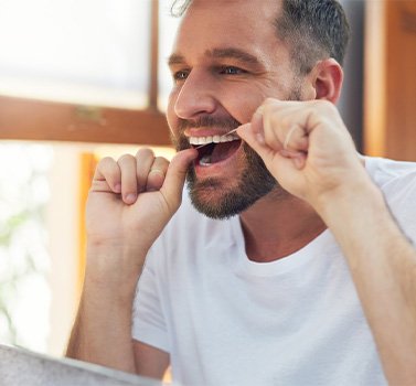 Man flossing his teeth.